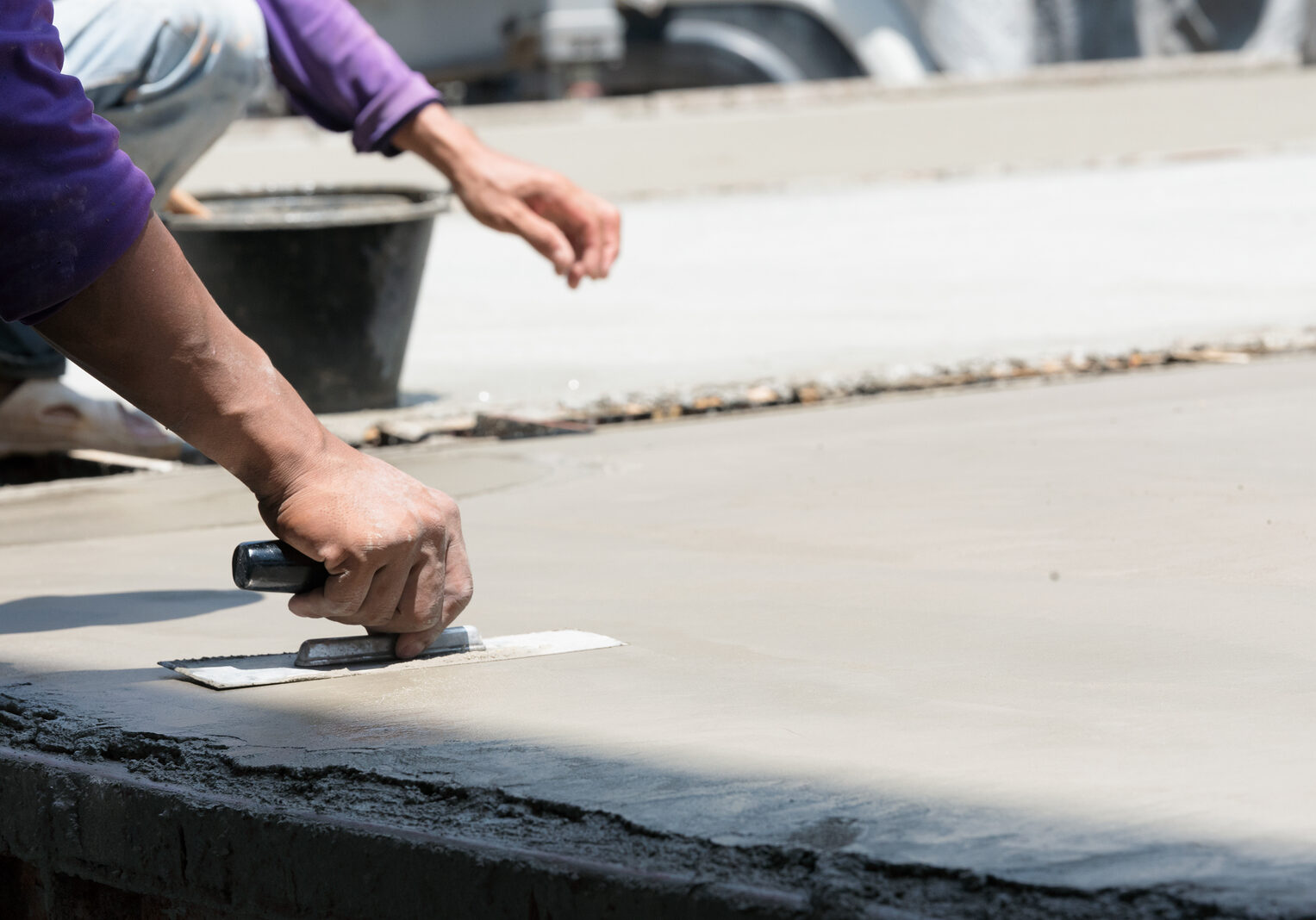 Plasterer concrete cement work. using a trowel to smooth or leveling concrete slab floor work step of the building construction.