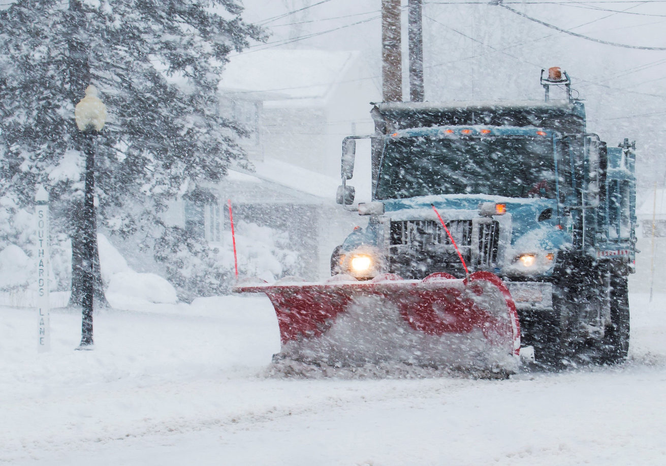 Snow plow is plowing the roads during a storm DRIVEWAY & PARKING LOT PLOWING